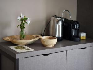 a counter with two bowls and a vase with flowers at Domus Natura, un'oasi verde tra Padova e Venezia in Vigonza