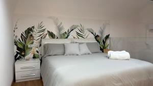 a bedroom with a white bed with a tropical headboard at Figli Di Agata in Catania