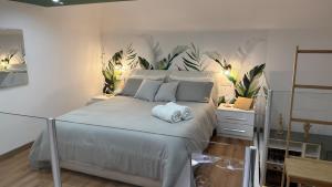 a bedroom with a large white bed with plants on the wall at Figli Di Agata in Catania