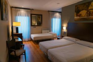 a hotel room with two beds and a couch at SNÖ Hotel Ciudad de Sabiñánigo in Sabiñánigo +24 photos