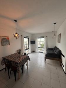 ein Wohnzimmer mit einem Tisch und einem Sofa in der Unterkunft Departamento en el centro de Rafaela in Rafaela