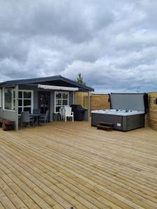 a large deck with a grill on top of a house at Hreiðrið cozy cabin in the countryside in Selfoss +6 photos