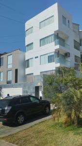 Casa Portada del Sol في La Molina: سيارة سوداء متوقفة أمام مبنى