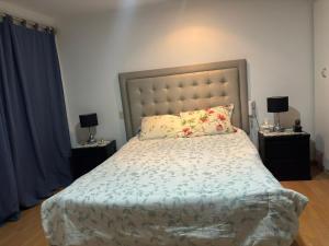 Casa Portada del Sol في La Molina: غرفة نوم بها سرير وطاولتين جانبيتين مع مصابيح