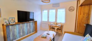 ein Wohnzimmer mit Fernseher und Tisch in der Unterkunft VK Ocean in Mimizan