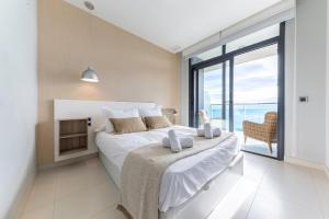 a bedroom with a large bed and a large window at Amazing Apartment in Benidorm - Sunset in Benidorm +45 photos