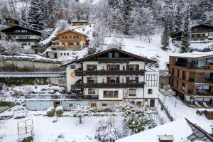 a building in the snow in a town at Haus Altenberger by we rent in Zell am See