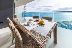 a dining room table with a view of the ocean at Amazing Apartment in Benidorm - Sunset in Benidorm
