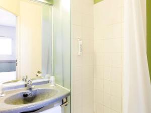un baño con lavabo y ducha en ibis Budget Pau Est, en Pau 57 fotos más