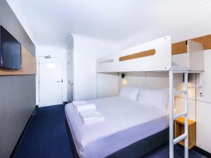 a small room with a bunk bed and a kitchen at Ibis Budget - Casula Liverpool in Liverpool +24 photos