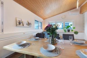 a dining room with a wooden table with glasses and flowers at Motel Ambiente - 4 Zimmer, 2 Bäder in Bad Säckingen