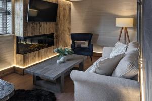 a living room with a couch and a fireplace at Scar View - Getaway for Two in Underbarrow