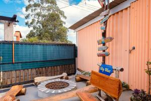 a patio with a fire pit and a bench and a sign at SkyBlue Guesthouse by Concavus in Campos do Jordão +11 photos