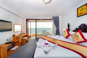 a hotel room with two beds and a television at Palado Hotel Mui Ne in Ấp Thiện Phước