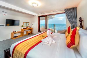 a bedroom with a large bed with a view of the ocean at Palado Hotel Mui Ne in Ấp Thiện Phước