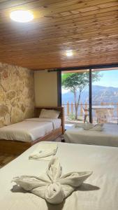 Un dormitorio con dos camas y una gran ventana. en Dana luxury huts, en Dana