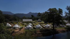 a group of tents in a field next to a river at L'camp and cafe' Kohchang in Trat