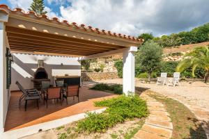 a patio with a table and chairs under a pergola at Villa Noelia by Escape Home in Santo Tomás