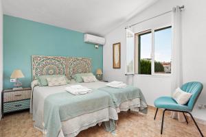 a blue and white bedroom with a bed and a chair at Villa Noelia by Escape Home in Santo Tomás