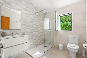 a bathroom with a shower and a toilet and a window at Villa Noelia by Escape Home in Santo Tomás +26 photos