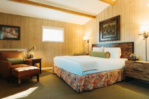 南派恩斯Pine Needles Lodge的带一张大床和一把椅子的卧室