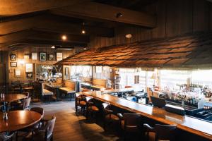 南派恩斯Pine Needles Lodge的带酒吧的餐厅，配有桌椅 更多6张照片