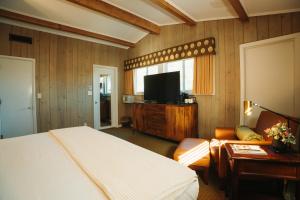 a bedroom with a bed and a flat screen tv at Pine Needles Lodge in Southern Pines
