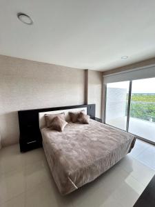 Apartamento Cartagena في كارتاهينا دي اندياس: غرفة نوم بسرير كبير ونافذة كبيرة