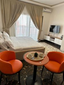 Résidence Diba في داكار: غرفة نوم بها سرير وكرسيين وطاولة