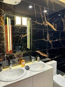 Résidence Diba في داكار: حمام به مغسلتين وجدار من البلاط الأسود