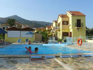 2 niños en la piscina de una villa en Stella Apartments, en Marathokampos