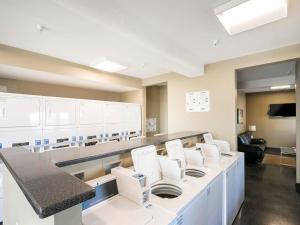 una sala d'attesa con sedie bianche e bancone di Riverfront Condo Walk Downtown Pool Parking a Nashville