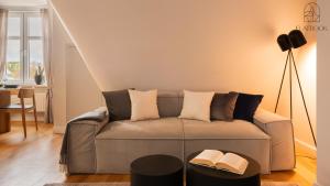 ein Wohnzimmer mit einem Sofa mit zwei Büchern darauf in der Unterkunft Flatbook Kordeckiego - Apartamenty Przy Morzu in Sopot