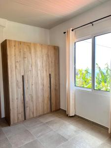 une pièce avec une armoire en bois et une fenêtre dans l'établissement Bravas House 1, à Tábua