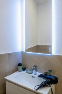 Un lavabo de baño con grifo y espejo. en PrimeLoft Cathedral-Exclusive Suite, en Ferrara 38 fotos más