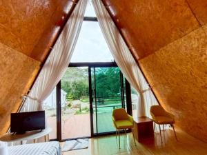 a bedroom with a bed and two chairs in front of a window at ห่มดาวฮิลล์ in Amphoe Chiang Khan