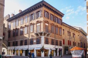 Un gran edificio de ladrillo en la esquina de una calle. en PrimeLoft Cathedral-Exclusive Suite, en Ferrara
