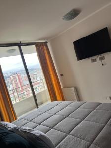 a bedroom with a bed and a large window at Viña del Mar Department in Viña del Mar