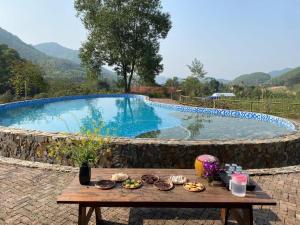 a table with food on it next to a swimming pool at Háo Hức Village, Thai Nguyen in Thái Nguyên