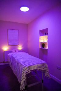 Zimmer mit einem Bett in einem lila Zimmer in der Unterkunft Country Retreat Sleeping 15 - Bron Menai in Newborough