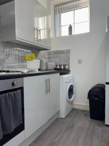 una cocina blanca con una lavadora dentro en Modern Studio - Central Location - Parking & Wi-Fi, en Bolton 12 fotos más