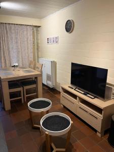 ein Wohnzimmer mit Fernseher und Tisch und Stühlen in der Unterkunft Hengelhoef Acacia 3 in Drijhoeven