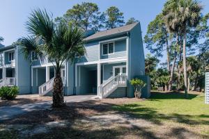 a house with a palm tree in front of it at 493 Egrets Pointe - Dove's Nest in Edisto Island