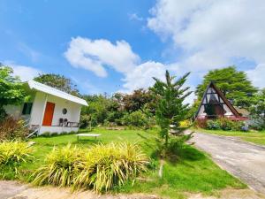 a house with a thatched roof and a grass yard at ห่มดาวฮิลล์ in Amphoe Chiang Khan