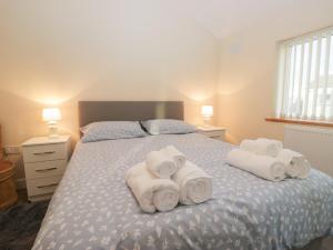 een slaapkamer met een bed met handdoeken erop bij Mables in Silloth