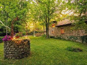 una casa in pietra in un cortile con un muro di pietra di Mulino del Lentino a Nibbiano