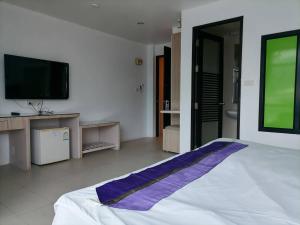 a bedroom with a large bed with a tv on the wall at AtWhitePatong in Patong Beach