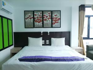 a bedroom with a large bed with two pillows at AtWhitePatong in Patong Beach