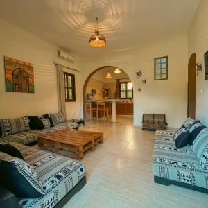 a living room with couches and a coffee table at Sahara Lounge in Tozeur