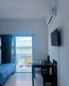 a bedroom with a bed and a desk with a television at El Amanecer de Chiltepec in Chiltepec